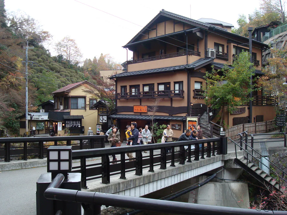 Rue en pente et ryokans de Kurokawa Onsen, où le dernier kilomètre compte avec de gros bagages