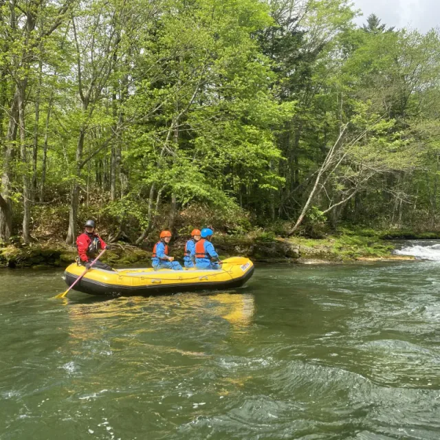 Furano river rafting participants wearing helmets and life jackets on the water