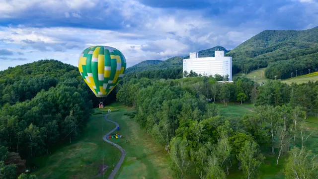 Furano hot air balloon in 2026. The summer experience is a five-minute tethered flight, while winter Free Flight is a weather-dependent wind-driven journey.