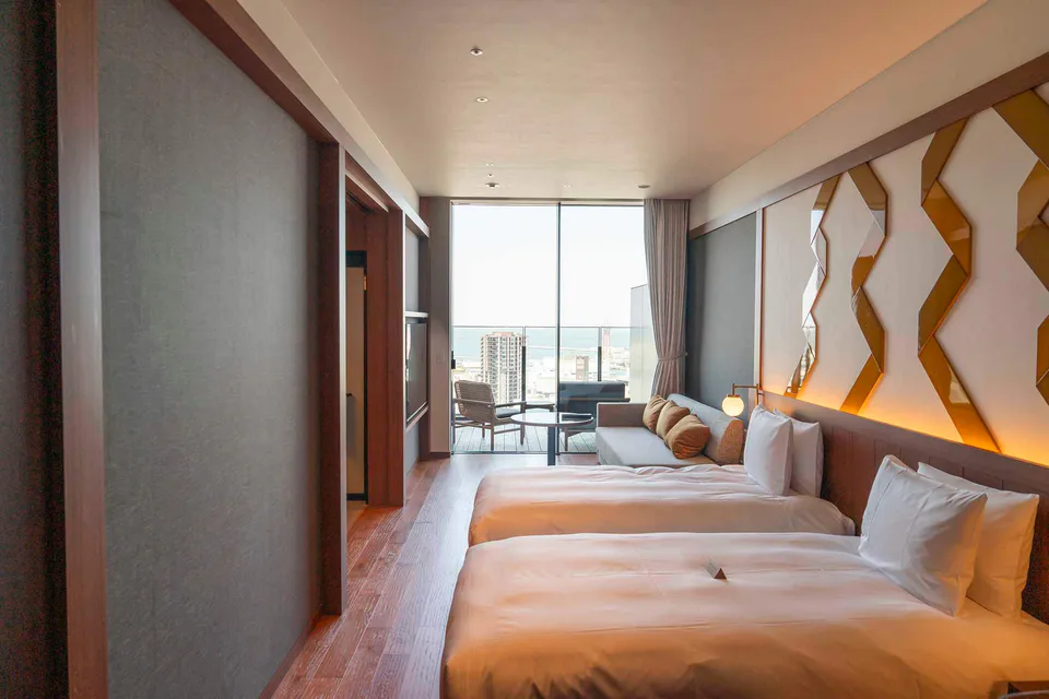Chambre Twin avec deux lits et espace de détente dans la chambre de l’hôtel ONE FUKUOKA HOTEL Terrace, idéale pour un voyage entre amies à Fukuoka.