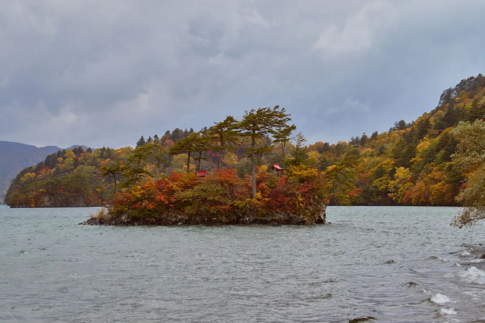 Autumn foliage around a small shrine and lakeshore at Lake Towada for choosing an overnight base