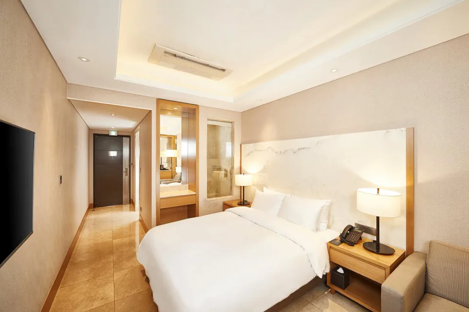 Arban Hotel Busan deluxe guest room with king bed and marble-accented interior