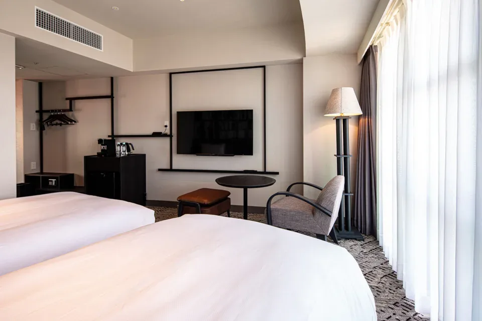 THE BASICS FUKUOKA Chapter guest room with twin beds and lounge seating