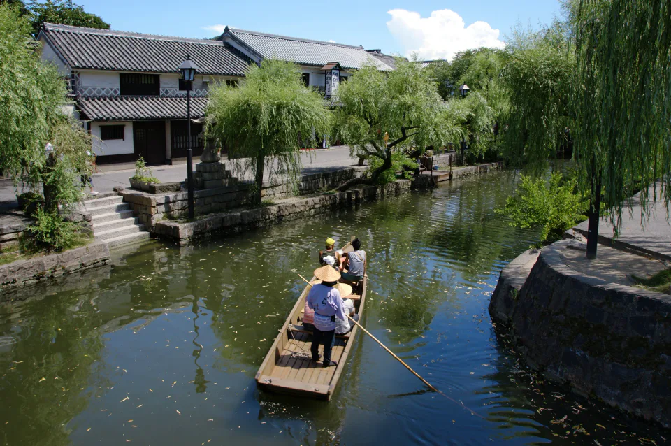 เรือคลองใน Kurashiki Bikan ผ่านกำแพงสีขาวและต้นหลิว ก่อนเที่ยวสุดท้ายเวลา 15:00 ในฤดูร้อน 2026