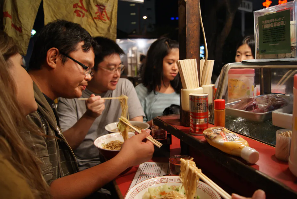 Vue nocturne des stands au bord de la rivière à Nakasu, Fukuoka, et organisation du dîner pour la première soirée