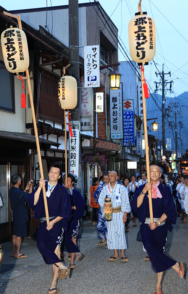 ผู้ร่วมงาน Gujo Odori เต้นเป็นวงบนถนนยามค่ำคืน
