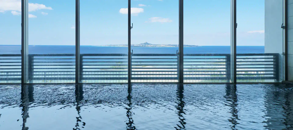 Bain intérieur avec vue sur la mer au Jurassic Onsen Churaumi no Yu de l'Orion Hotel Motobu