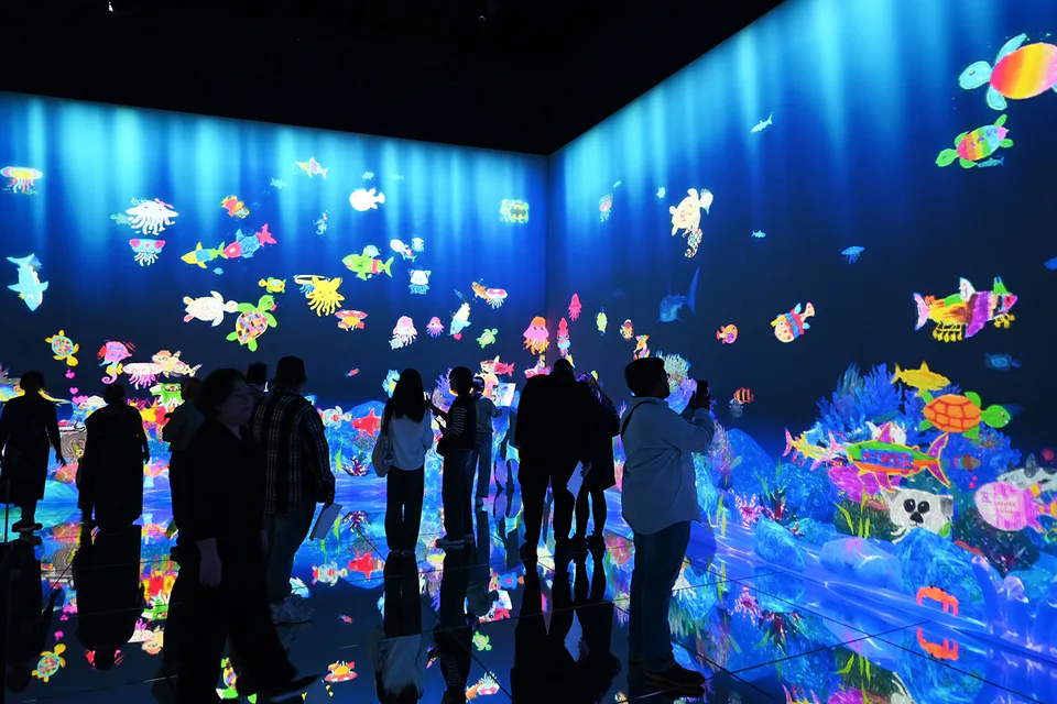 Sketch Ocean at teamLab Borderless with visitor-drawn sea creatures swimming across the digital aquarium