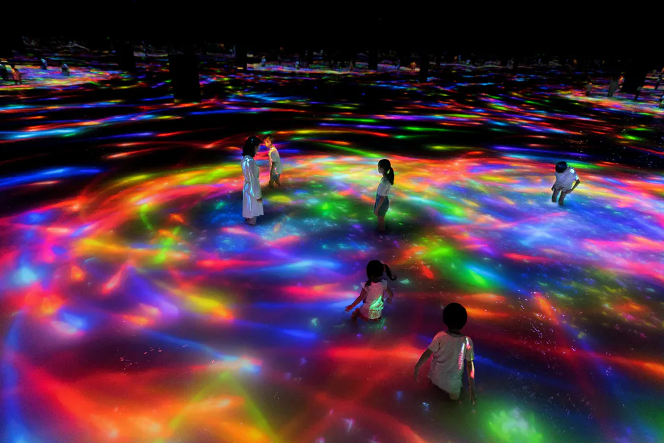 Visitors wading through an interactive water artwork at teamLab Planets Tokyo