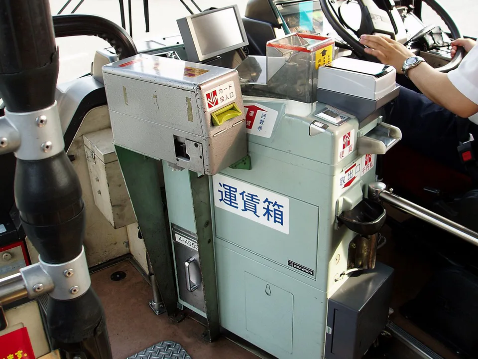 A Japanese bus fare box with coin changer and IC-card reader beside the front exit