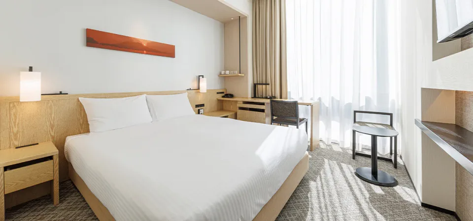 JR Kyushu Hotel Blossom Shinjuku standard double room with warm wood interior