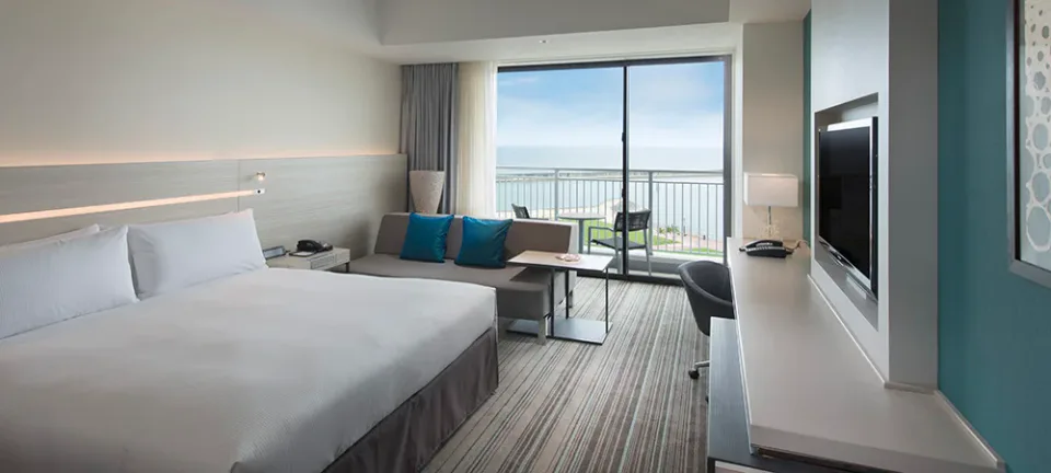 Hilton Okinawa Chatan Resort guest room with sofa and ocean-view balcony