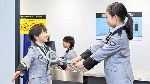 KidZania Fukuoka airport security activity, showing how the indoor city uses realistic work stations rather than simple play equipment