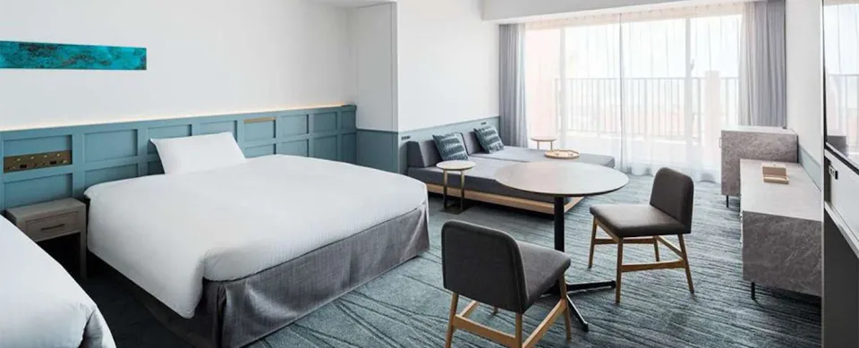 Lequ Okinawa Chatan Spa and Resort guest room with king bed and balcony