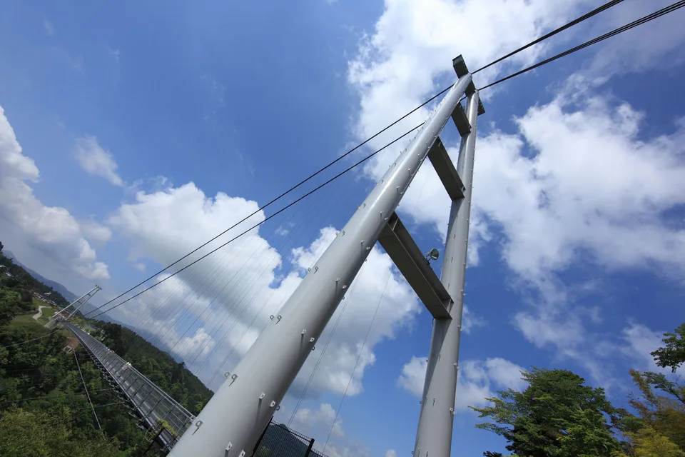 Kokonoe Dream Suspension Bridge crossing a forested autumn gorge in Oita