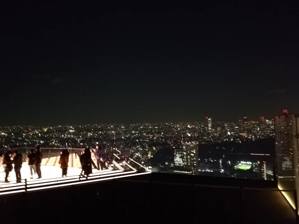 SHIBUYA SKY rooftop SKY STAGE at night; the open-air setting is the biggest difference versus other Tokyo observation decks