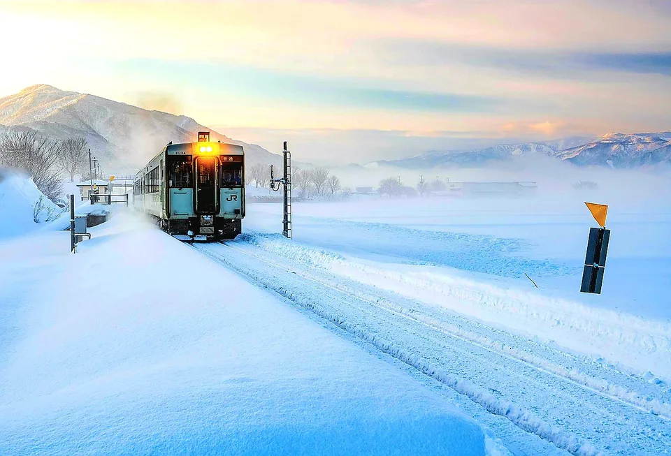 Train JR sur une voie enneigée dans le paysage hivernal de Hokkaido