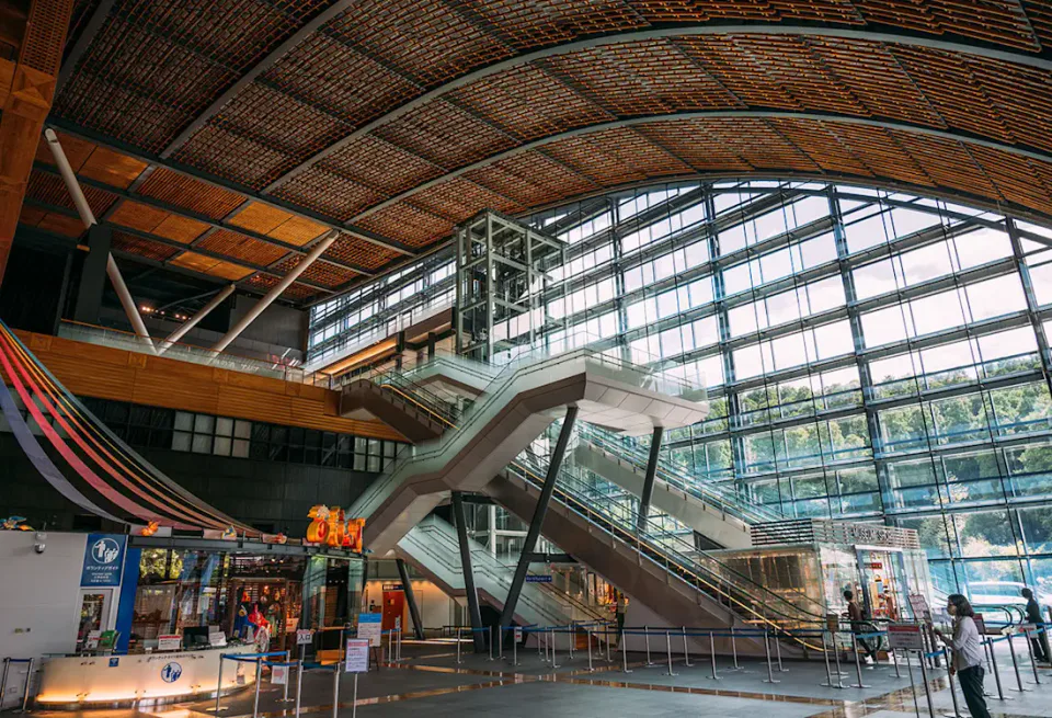 Main atrium inside Kyushu National Museum, with escalators leading from the entrance level toward the upper exhibition floors