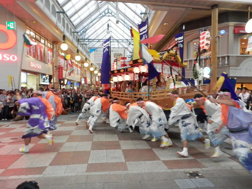 Le char-bateau du Nagasaki Kunchi dans la rue, montrant le mouvement qui se poursuit au-delà des tribunes officielles