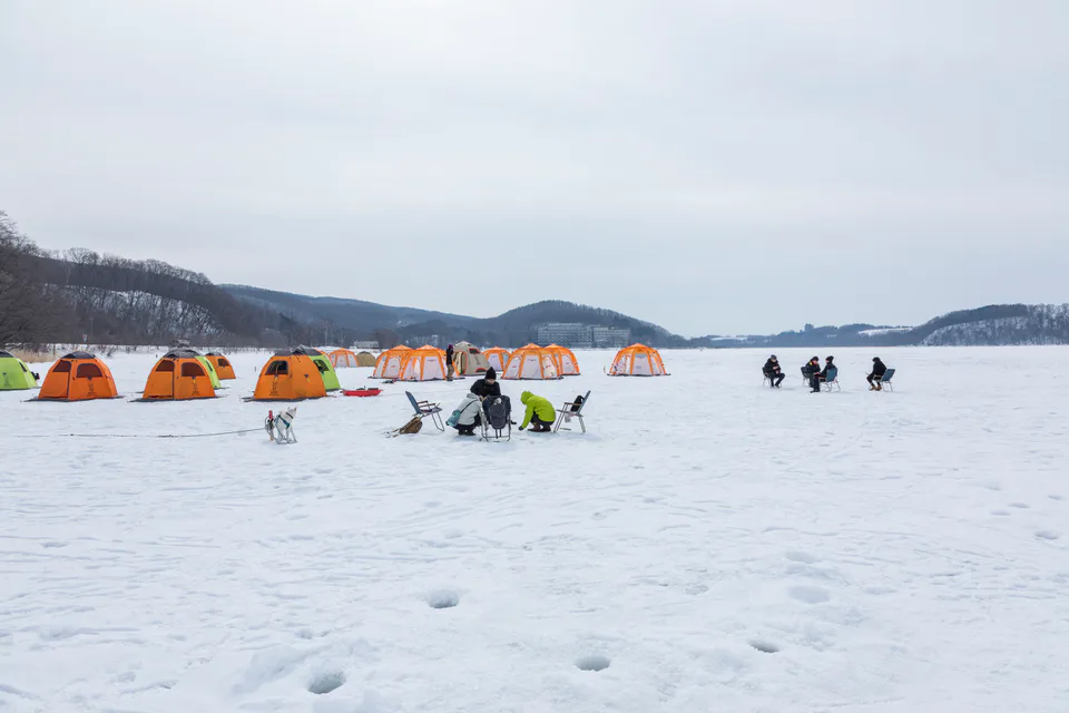 Pêche sur glace parmi des tentes orange sur le lac Abashiri gelé