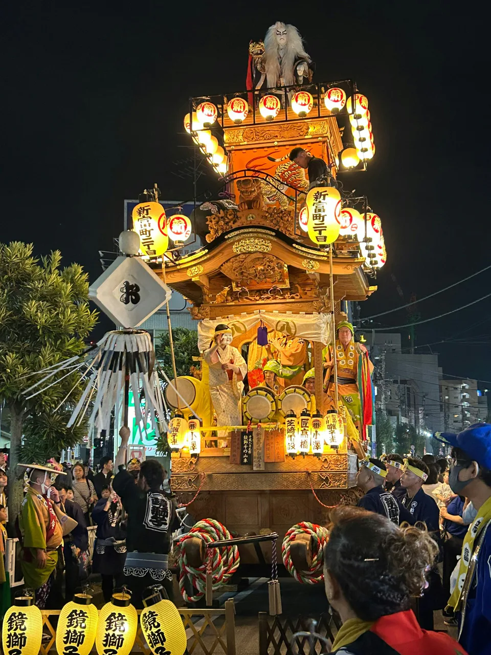 Une vue rapprochée des yatai illuminés du festival de Kawagoe, permettant d’admirer les détails de la sculpture sur bois et de la plateforme de musique