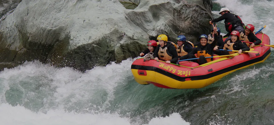 Happy Raft participants paddling through white water on the Yoshino River in Shikoku