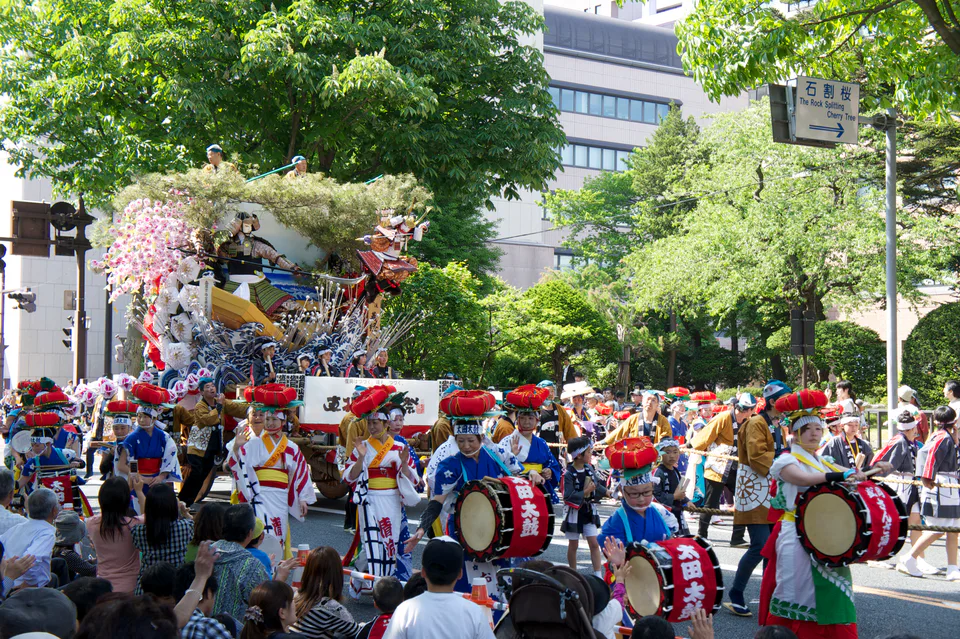 ทีมกลองและนักเต้น Morioka Sansa Odori เดินเป็นขบวนบนถนนใจกลางโมริโอกะ